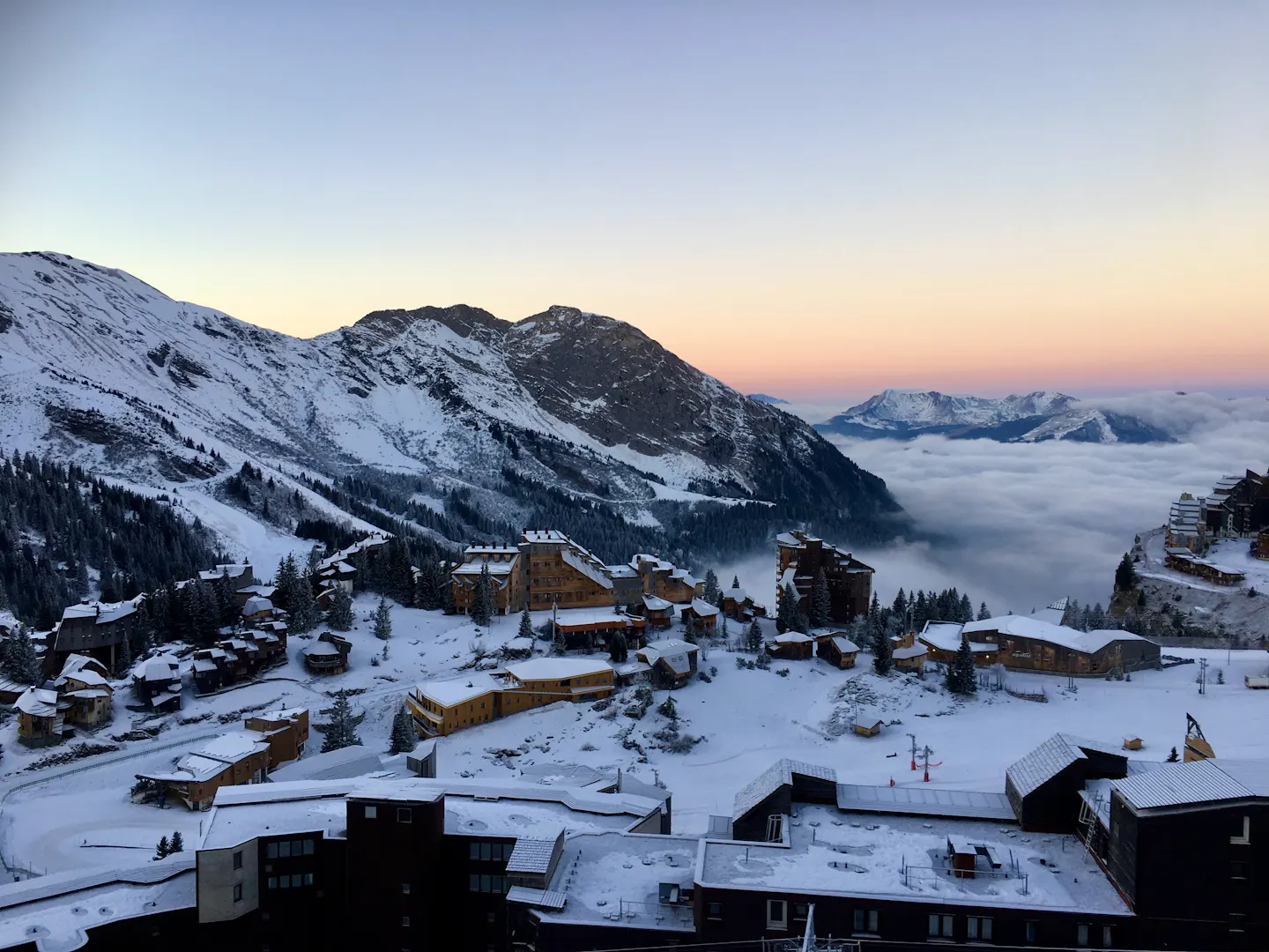 Morzine ski village at sunset with snowy mountains