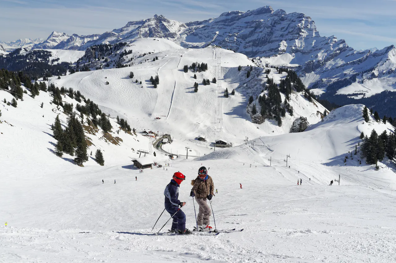 Skiers on a sunny slope in the Vaud Alps